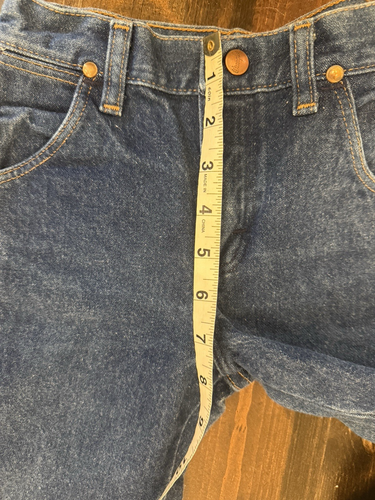 Blue denim kids’ Wrangler jeans, size 7, with brown leather patch, marked “Made in U.S.A.,” on waistband.