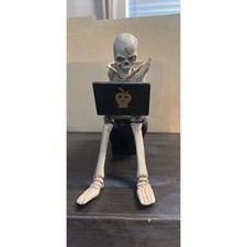 Skeleton working on laptop on toilet