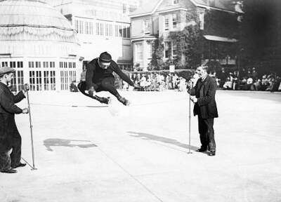 Roller skating A roller skater performs a high jump over a rop- 1910 Old Photo