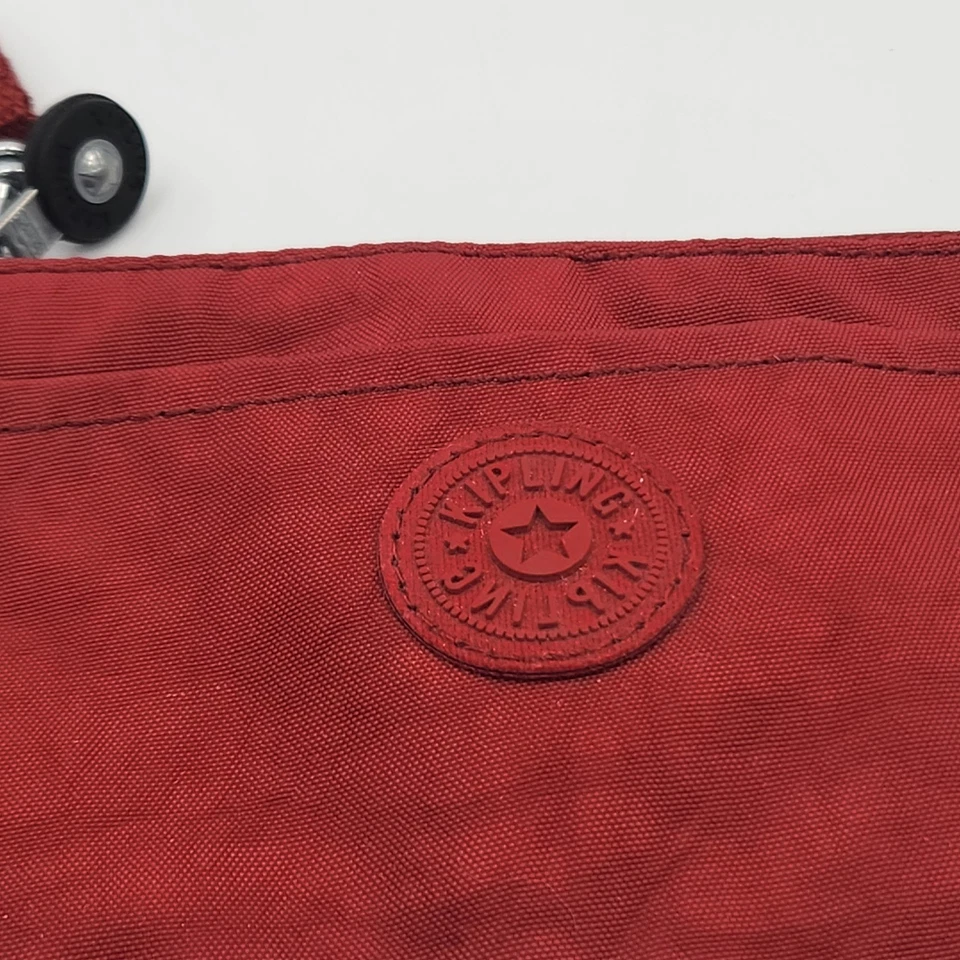 Bolso Clutch Muñequera Kipling Rojo 7" x 4.5" con Llavero Mono Etiqueta Rosa Usado en Excelente Condición Foto 2 de 4