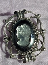 Vintage Whiting & Davis hematite glass cameo earrings set in an ornate silver-to