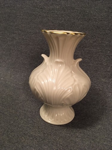 Cream Made in the USA 24K Lenox vase with fluted fan shape and gold rim on dark background.