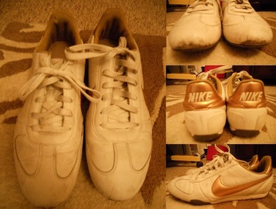 white nike trainers gold tick