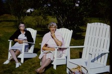 Vintage Photo Slide Two elderly women sit in white chairs outdoors.