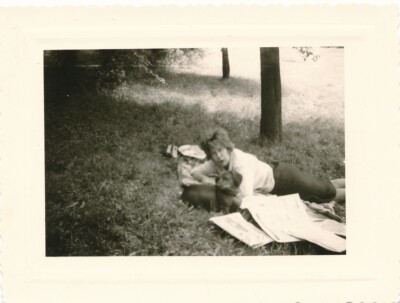 Snapshot Frau liegend im Gras mit Hund Dackel Zeitungen woman dog 