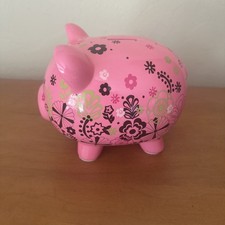 Pink Ceramic piggy bank features a floral design and a coin slot on top. 8  x6  