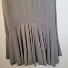 Grey maxi skirt with curved front and vertical tiered flow, made in USA, with black trim at hem and neckline.