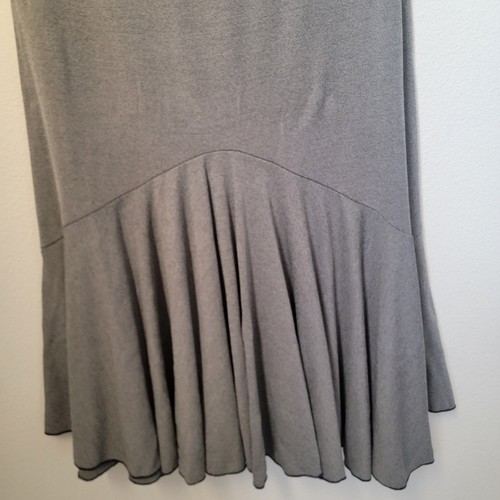 Grey maxi skirt with curved front and vertical tiered flow, made in USA, with black trim at hem and neckline.