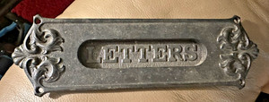 Antique cast iron door mail slot with embossed 'LETTERS' and ornate scrollwork