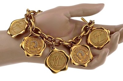 Vintage KARL LAGERFELD gold-tone bracelet features wax seal motif medallions.