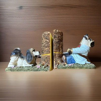 set of vintage resin bookends featuring two beagle-like dogs sawing a tree stump