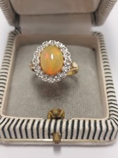 9ct Gold Ring Set With Oval Ethiopian Opal And A Halo Of Diamonds. Size O