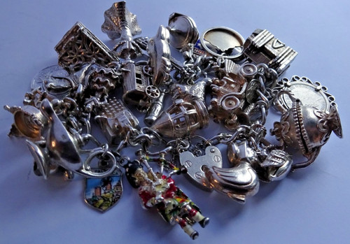 Vintage heavy solid silver charm bracelet &many curious silver charms inc moving