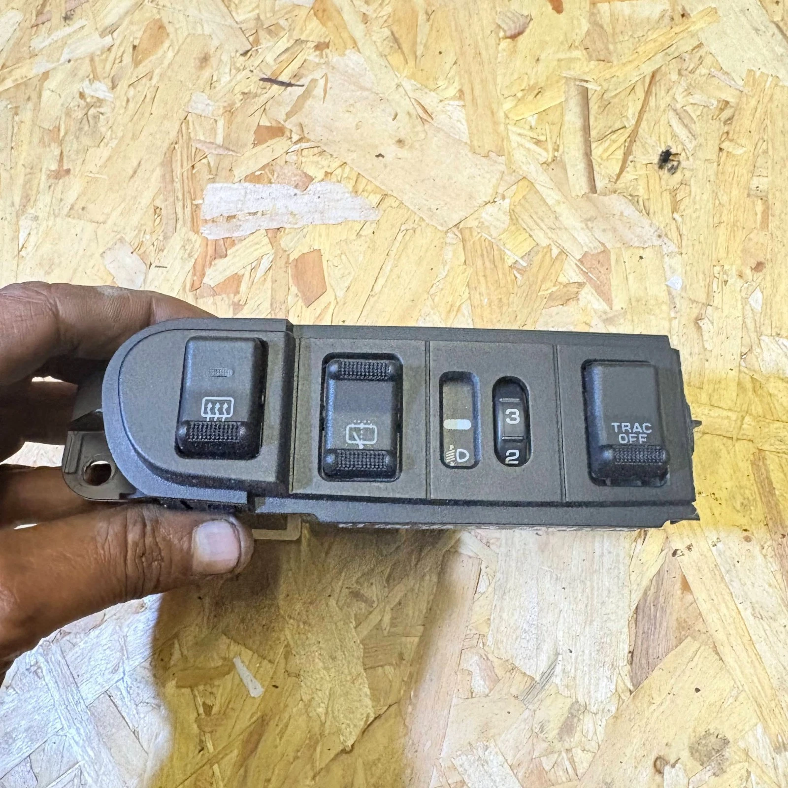 Chrysler PT Cruiser centre dashboard switch panel front showing demister rear wiper headlamp level and traction control buttons