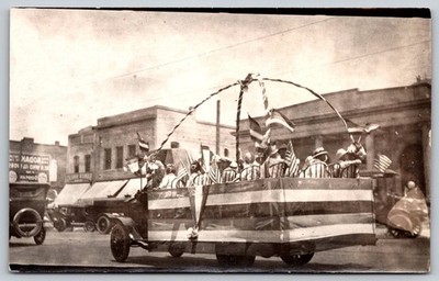 Vintage 1920s Parade Float with Flags in Small Town Street Scene Postcard AA102