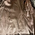 Brown fur-lined winter coat with satin-smooth fabric, featuring subtle stitched seams and a black tag reading “Made in USA.”