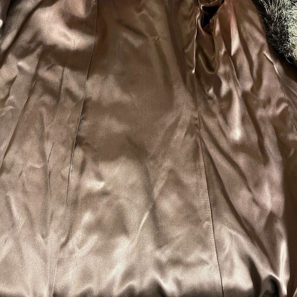 Brown fur-lined winter coat with satin-smooth fabric, featuring subtle stitched seams and a black tag reading “Made in USA.”