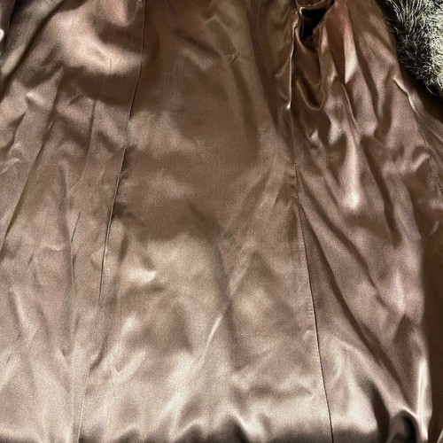 Brown fur-lined winter coat with satin-smooth fabric, featuring subtle stitched seams and a black tag reading “Made in USA.”