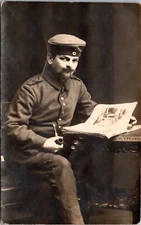 RPPC German Soldier Uniform Pipe Newspaper Studio Portrait 1915 Postcard