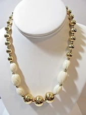 BRIGHT GOLD TONE BEADED NECKLACE WITH CARVED BEIGE LUCITE OVAL BEADS NAPIER