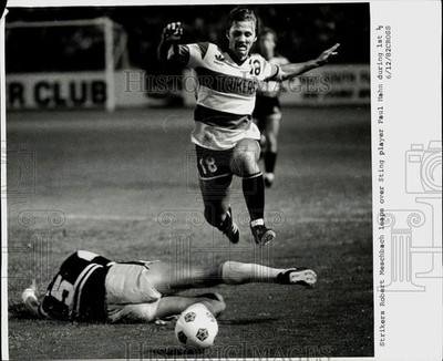 1982 Press Photo Strikers' Robert Meschbach leaps over Sting player Paul Hahn