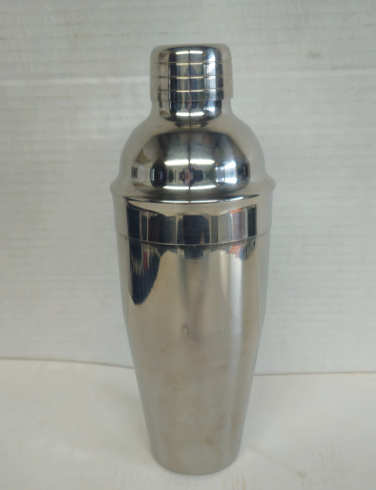 Tall silver-plated Art Deco cocktail shaker with a domed lid.