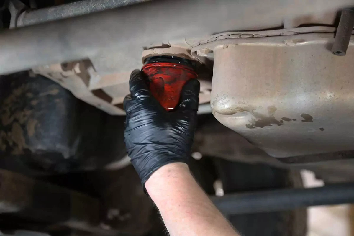 A mechanic installs a new transmission filter.
