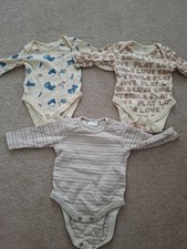 three long-sleeved baby bodysuits in neutral beige and cream tones 0-3 Months