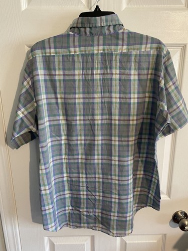 Men’s long-sleeve button-up shirt with green, purple, and yellow plaid pattern, displayed on a hanger against a white door.