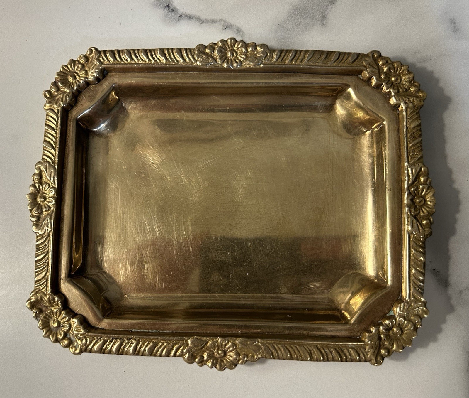 Small ornate brass catch-all tray on a white background.