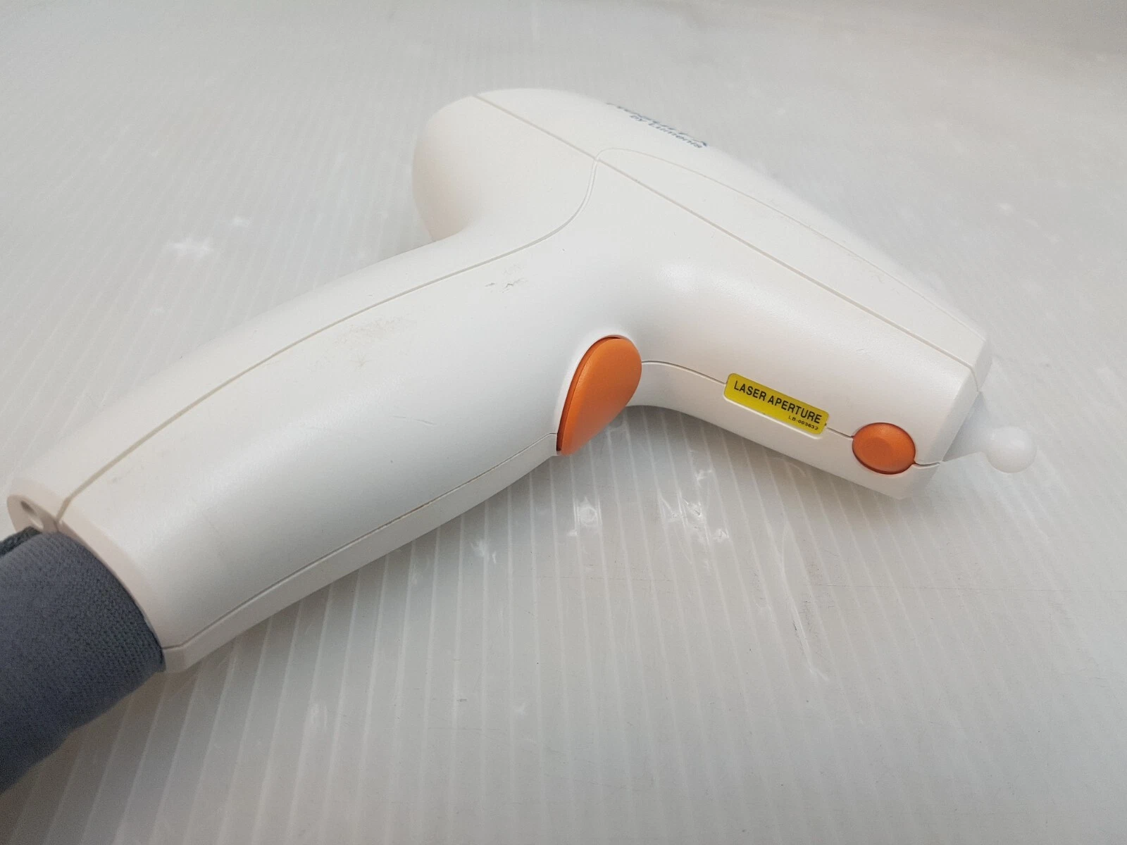 ResurFX handpiece with orange trigger buttons and laser aperture label