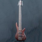 Ibanez SR506-BM used w/soft case, dark wood with gold hardware, six-string bass, on black background.