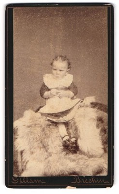 Fotografie Gillam, Brechin, Kind im Kleid sitzt auf Fell CDV /Kabinett-Foto