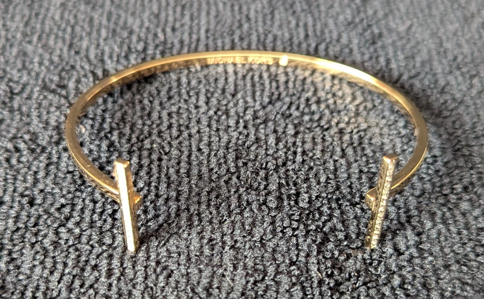 Bracciale aperto Michael Kors. Tono oro con strass.