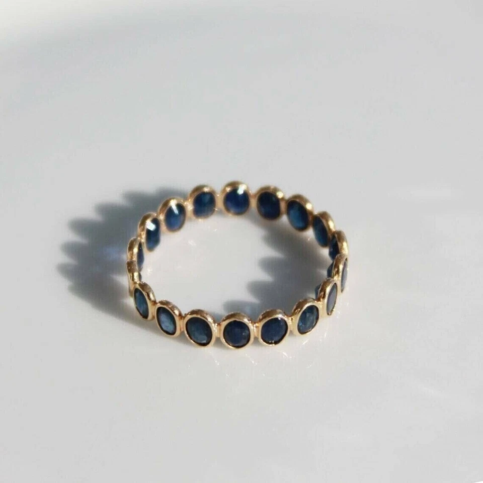 Anillo banda de eternidad ovalado de zafiro azul simulado de 1,50 quilates enchapado en oro amarillo de 14 quilates Foto 4 de 4
