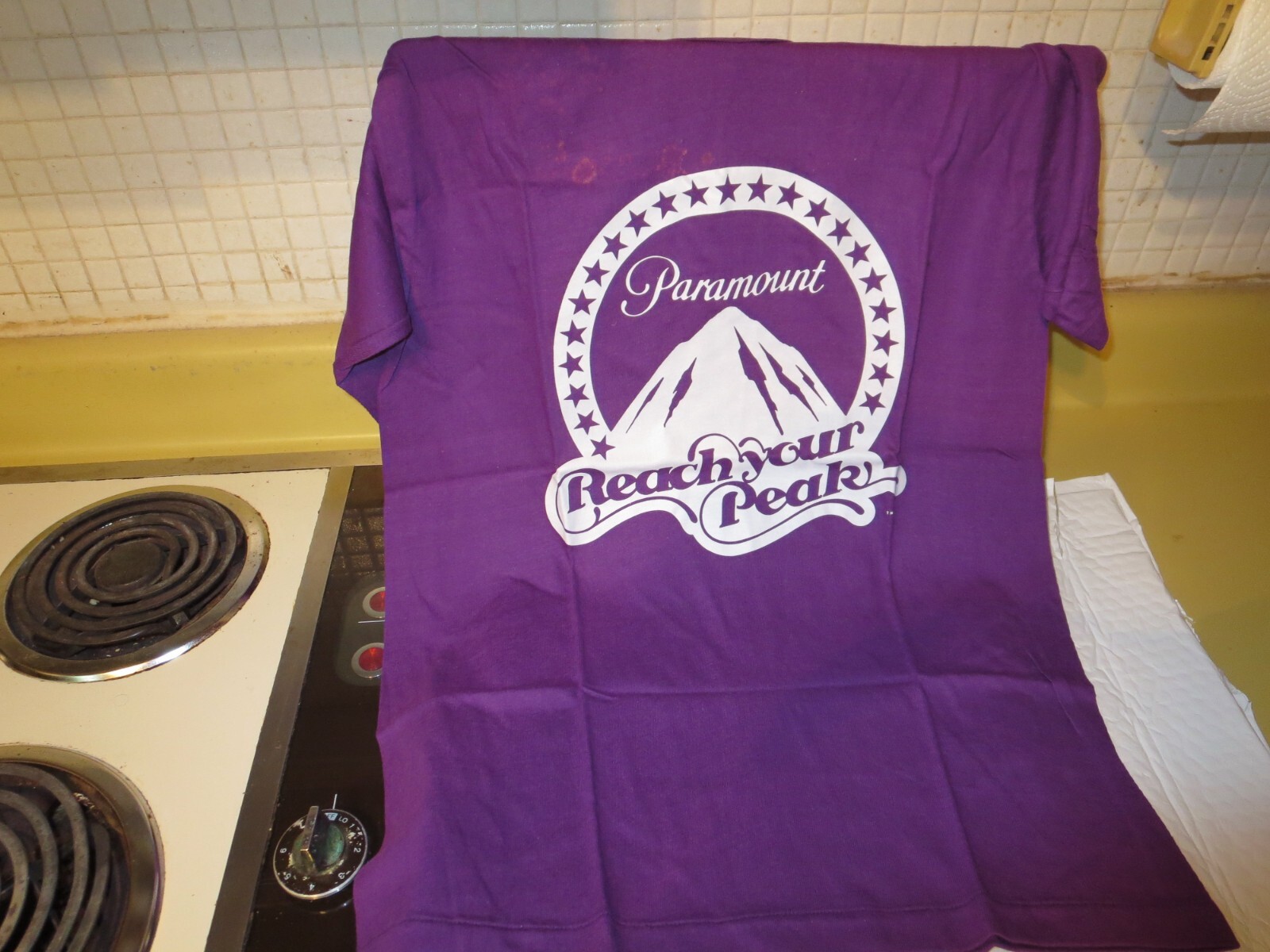 ALTRA PARAMOUNT PCTURES: Reach Your Peak (NUOVA MAGLIETTA 1979 viola GRANDE) Studio Store