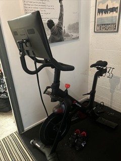 Peloton Fitness Bike. VGC. Size 9 shoes mat & weights. Added swivel screen.