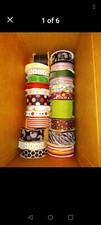 130 rolls of new and used ribbon in assorted colors ranging from 3/8"-3" widths