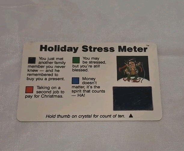 A 1990s Spencer's Gifts 'Holiday Stress Test Card' novelty — hold your finger on it and it 'reads' your stress, a perfect little time capsule of 90s gag culture.