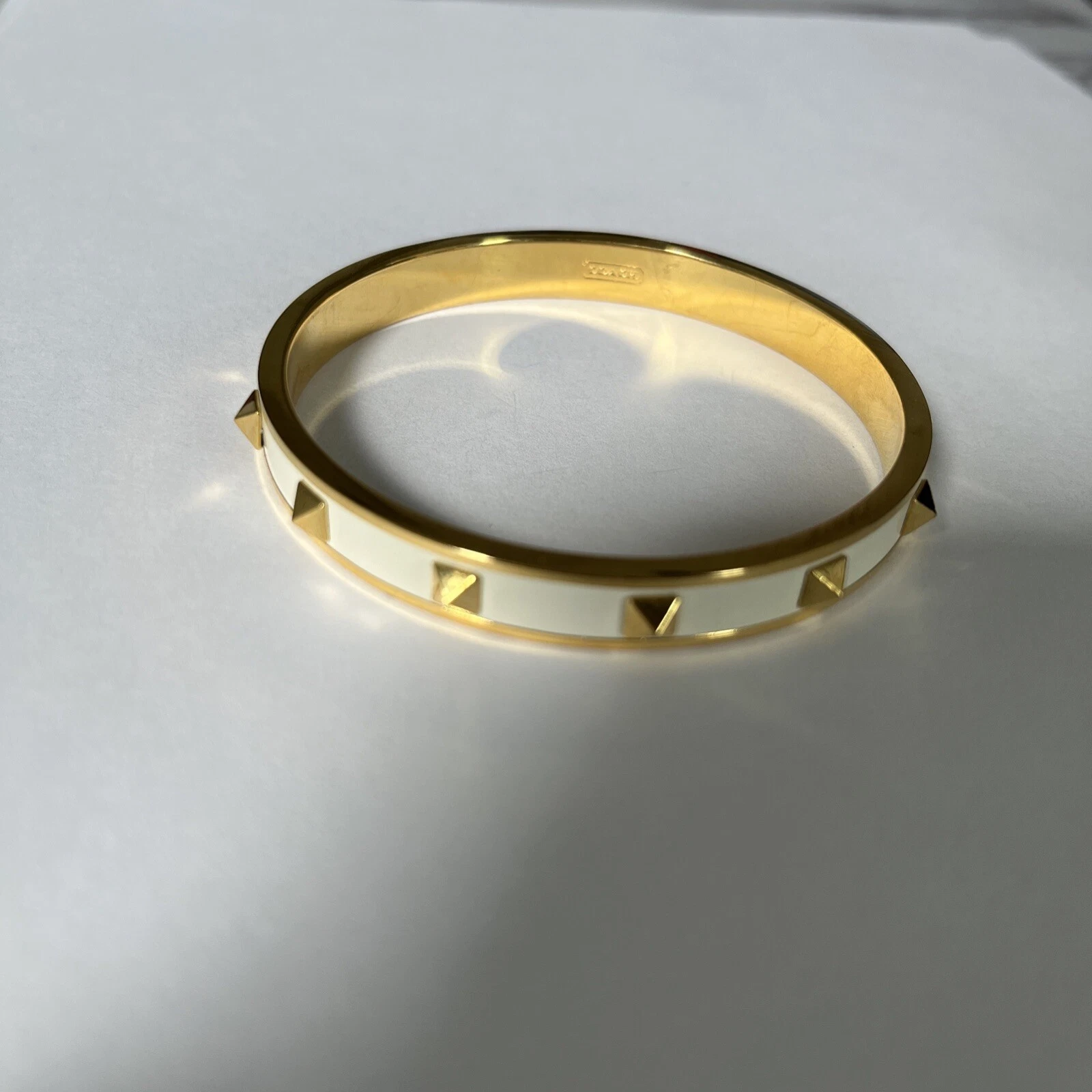 OFF WHITE Bracciale Coach in metallo color oro con borchie avorio bianco sporco