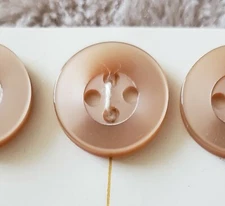 Nine tan four-hole flat button 9/16 inch resin buttons still on the card