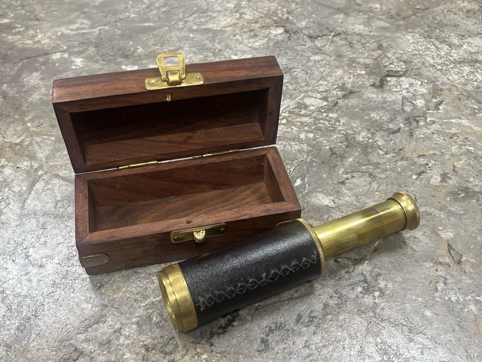 A leather-and-brass collapsible pocket telescope with case — the kind of thing a Victorian gentleman would fish out of his waistcoat.