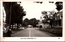 Main Street Rushford New York Postcard RPPC Antique Cars CL Gordon & Son Sign