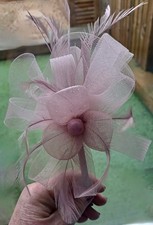 Pink fascinator with alice band and feathers.