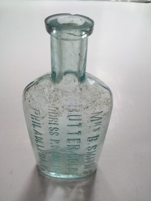 ANT AQUA EMB GLASS BOTTLE MRS. B SMITHS BUTTER COLOR PHILA PA OVAL SHAPE 5'' CHIP