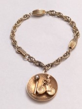 Pulsera vintage de mediados de siglo con dije de dama en bicicleta tono dorado