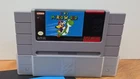 New ListingSuper Mario World (SNES) Game, Cartridge Protector And Manual
