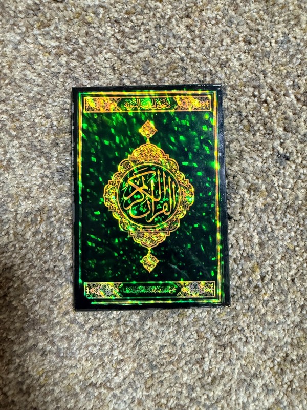 Decorative glass edition of the Holy Quran with ornate Arabic calligraphy.