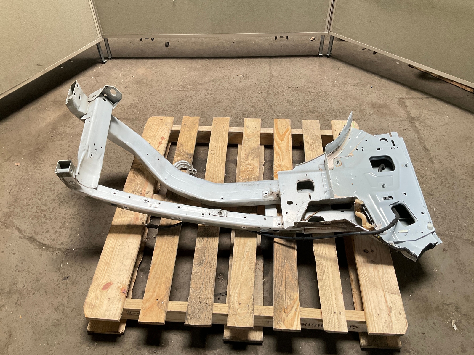 Silver 13-18 RAM 1500 front left driver frame apron radiator support with exposed bolts, resting on a wooden pallet.