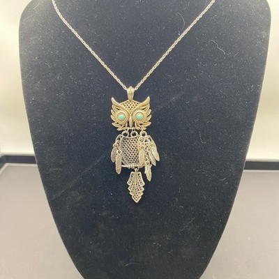 Elegant owl pendant necklace featuring turquoise-colored eye accents.
